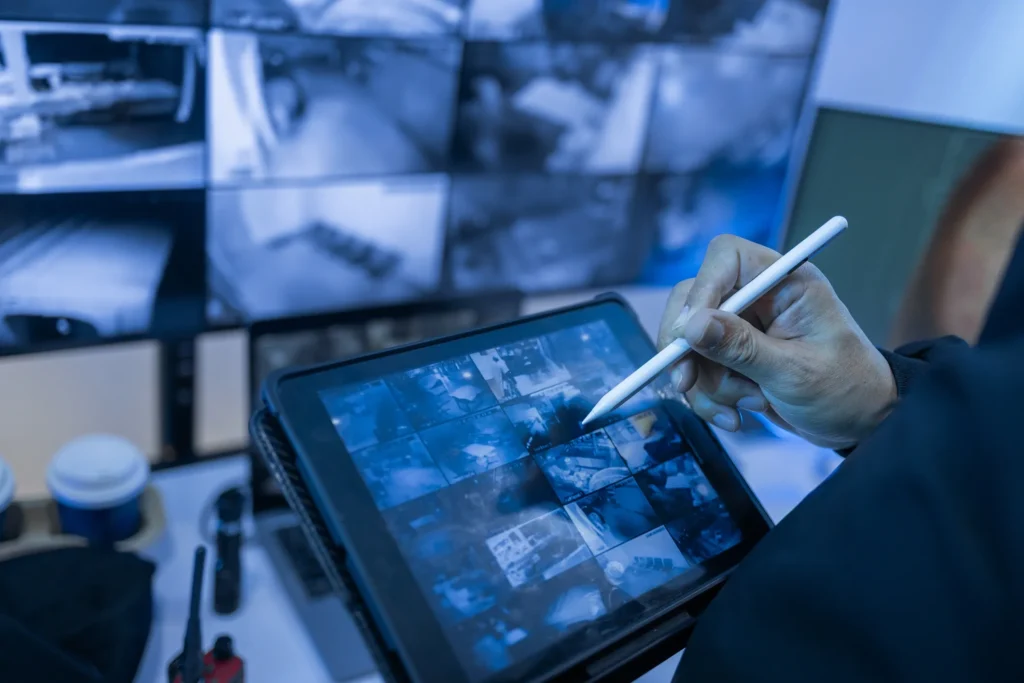 security operator monitoring multiple CCTV cameras on a digital tablet